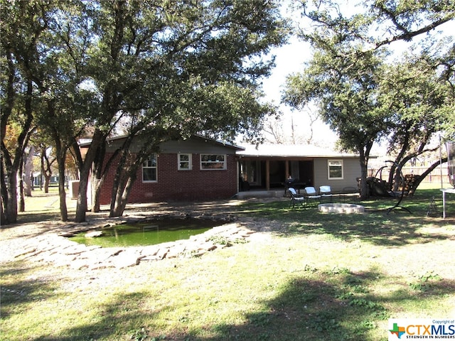 rear view of property featuring a patio area and a yard