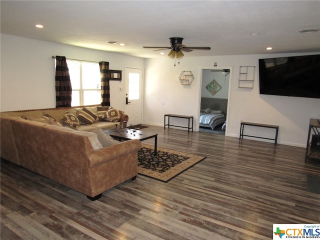 living room with dark wood-type flooring and ceiling fan