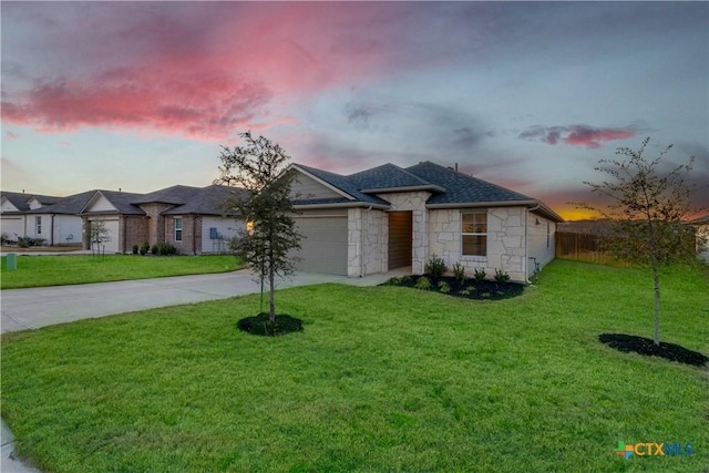 view of front of home featuring a yard, stone siding, concrete driveway, and an attached garage