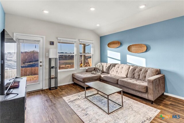 living room featuring vaulted ceiling, recessed lighting, baseboards, and wood finished floors