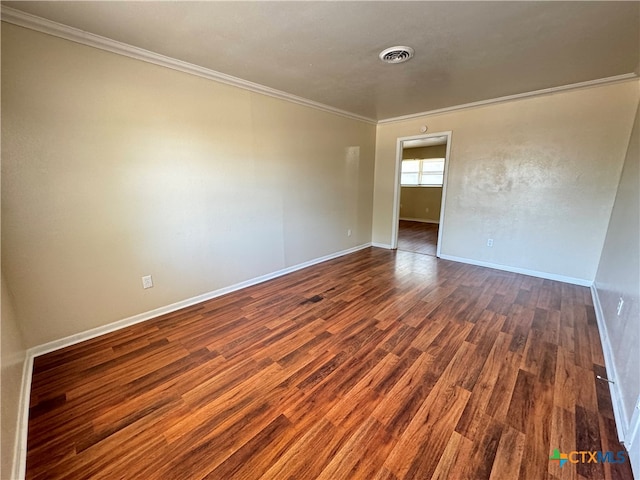 empty room with dark hardwood / wood-style floors and ornamental molding