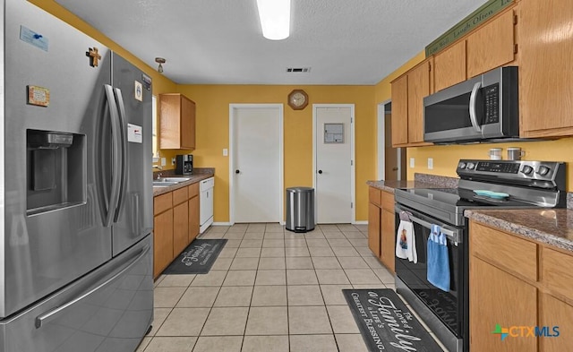 kitchen with visible vents, dark countertops, appliances with stainless steel finishes, and light tile patterned flooring