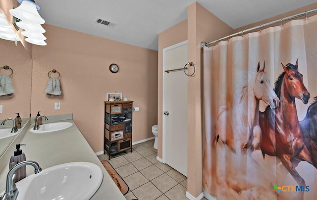 bathroom featuring tile patterned flooring, toilet, visible vents, and a sink