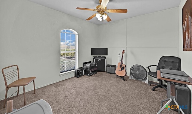 carpeted office space with a ceiling fan