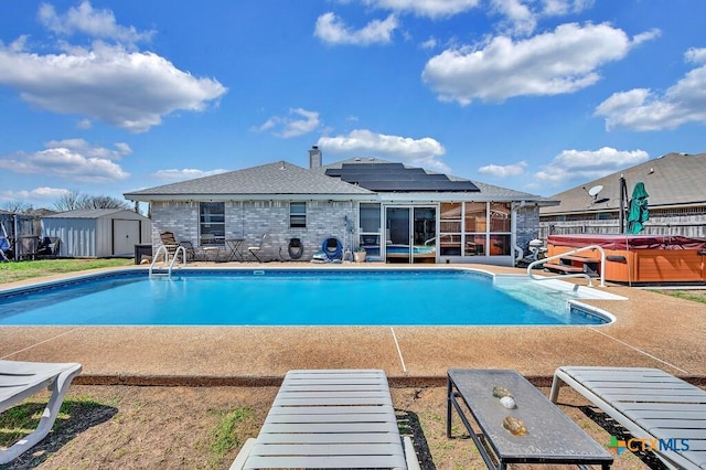 view of swimming pool featuring a storage unit, a hot tub, fence, an outdoor structure, and a patio area