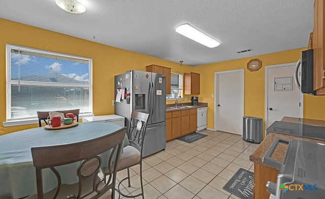 kitchen with dark countertops, visible vents, appliances with stainless steel finishes, and light tile patterned floors