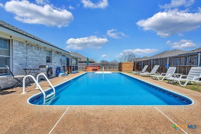 view of pool featuring a fenced in pool, a hot tub, a fenced backyard, and a patio area