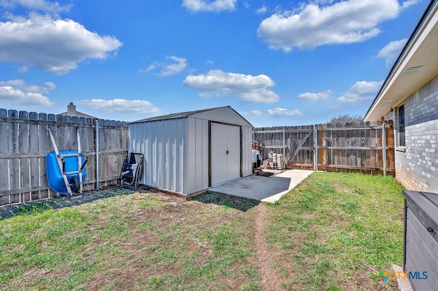 view of yard with a storage shed, a fenced backyard, and an outdoor structure