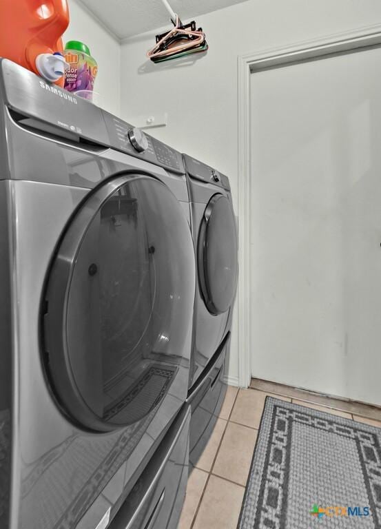 laundry room with light tile patterned floors, laundry area, and washing machine and clothes dryer