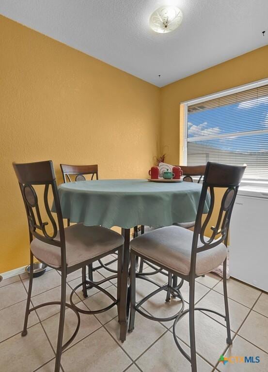 dining room with light tile patterned flooring and a textured ceiling