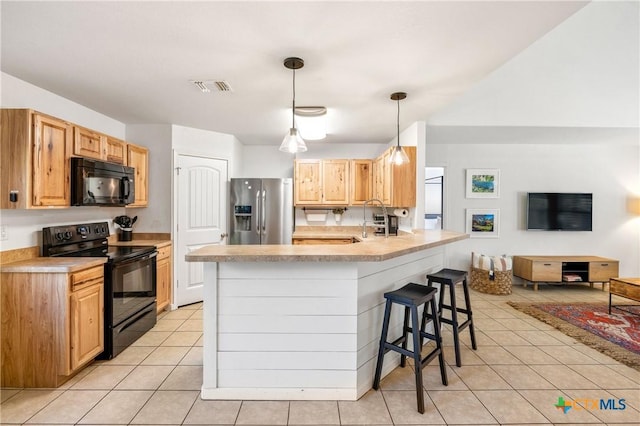 5445 Chimney Rock, Canyon Lake, TX 78133 - kitchen featuring a breakfast bar, pendant lighting, a kitchen island with sink, light tile patterned floors, and black appliances