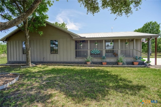 1319 County Road 339, Shiner, TX 77984 - view of front of house with board and batten siding, a front lawn, and metal roof