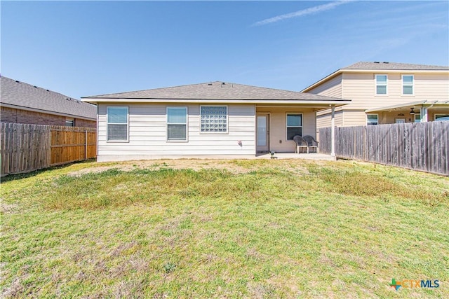 back of house featuring a lawn, a patio area, and a fenced backyard