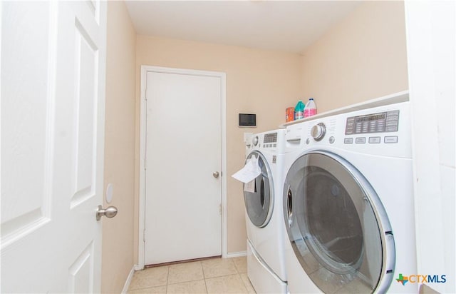 laundry room featuring laundry area, light tile patterned floors, baseboards, and separate washer and dryer