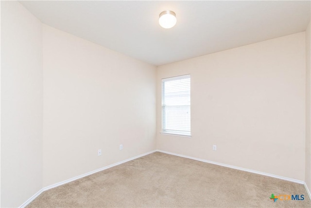 unfurnished room featuring light carpet and baseboards