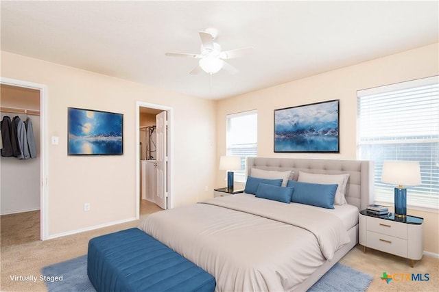 bedroom with light carpet, a spacious closet, baseboards, and a closet