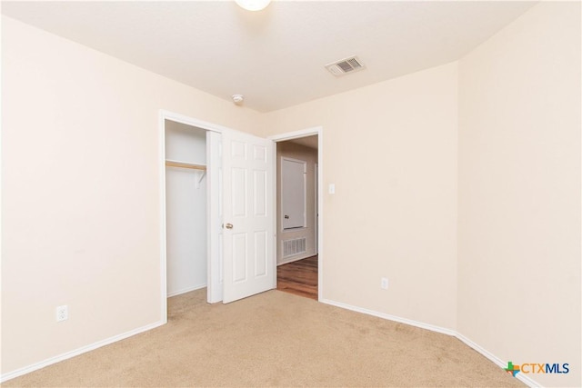 unfurnished bedroom with carpet, visible vents, and baseboards