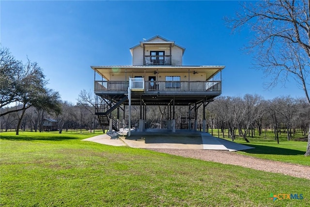 back of property with a carport, a yard, and covered porch