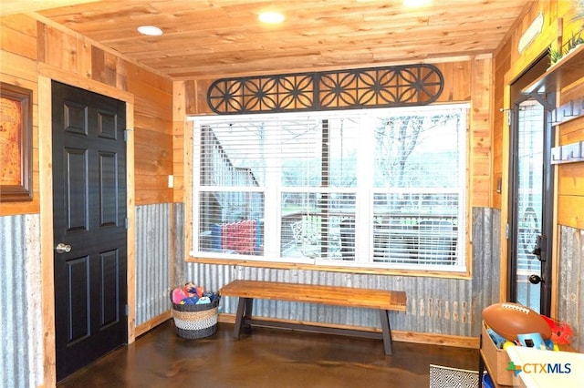 interior space featuring wood ceiling and wood walls