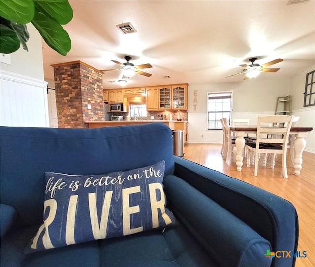 living room featuring ceiling fan and light hardwood / wood-style flooring