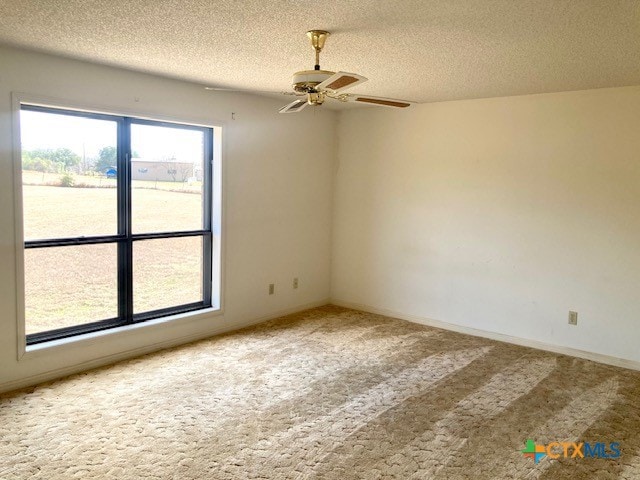 carpeted spare room with ceiling fan and a textured ceiling