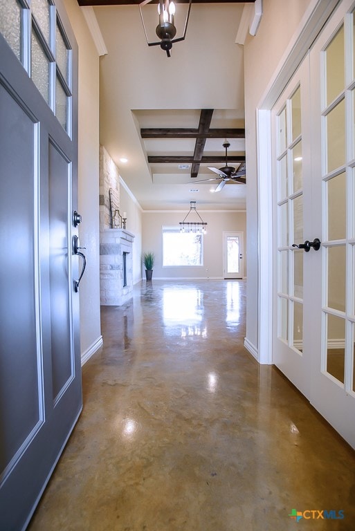 corridor with french doors, coffered ceiling, concrete flooring, crown molding, and beam ceiling