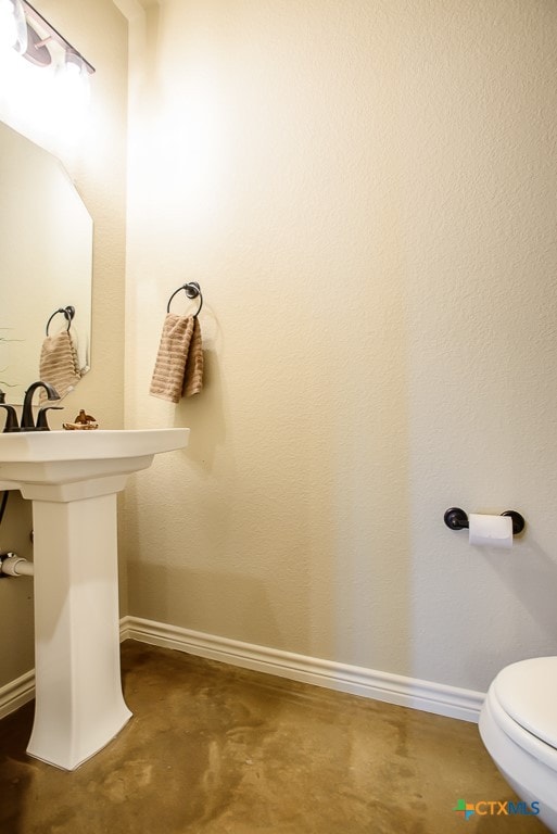 bathroom featuring toilet and concrete flooring