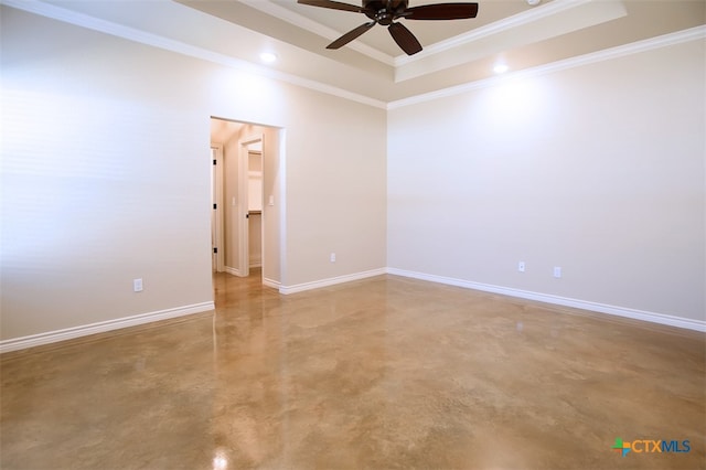 empty room with ornamental molding, ceiling fan, a tray ceiling, and concrete floors