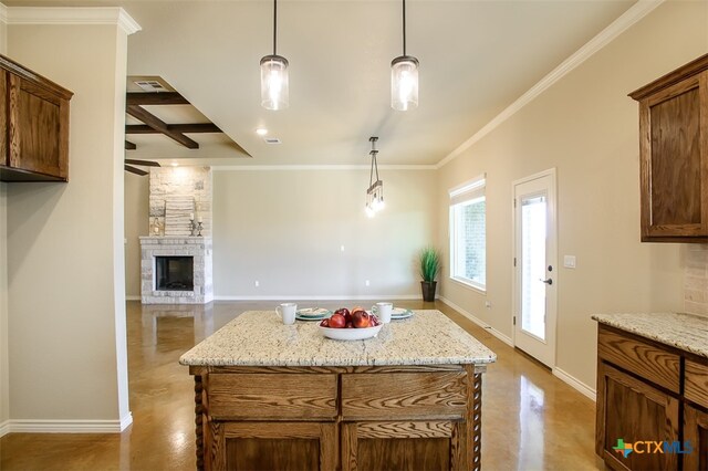 kitchen featuring a stone fireplace, pendant lighting, and a kitchen island