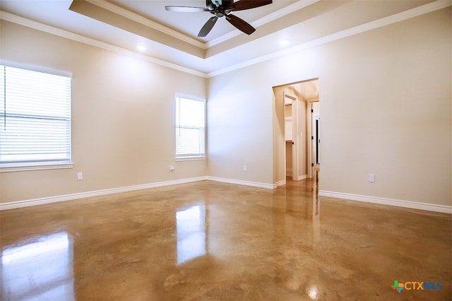 empty room featuring concrete flooring, ceiling fan, a raised ceiling, and crown molding