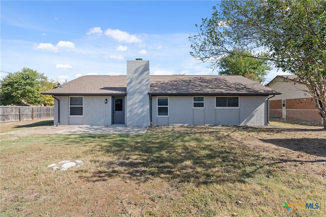 back of property with a yard and a patio area