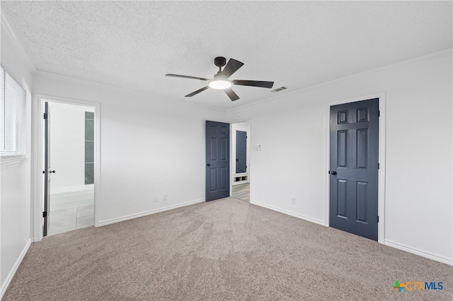 unfurnished bedroom with ensuite bathroom, carpet flooring, a textured ceiling, and ceiling fan