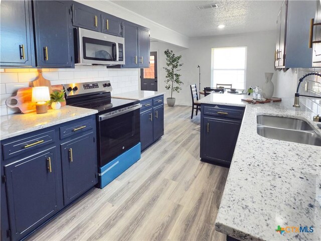 kitchen featuring stainless steel appliances, light hardwood / wood-style floors, sink, and ornamental molding