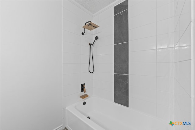 bathroom featuring a textured ceiling and tiled shower / bath combo