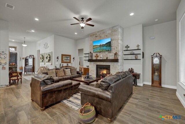 588 Vale Ct, New Braunfels, TX 78132 - living room with hardwood / wood-style floors, a stone fireplace, and ceiling fan