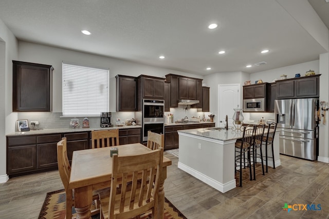 588 Vale Ct, New Braunfels, TX 78132 - kitchen featuring stainless steel appliances, sink, an island with sink, and light hardwood / wood-style flooring