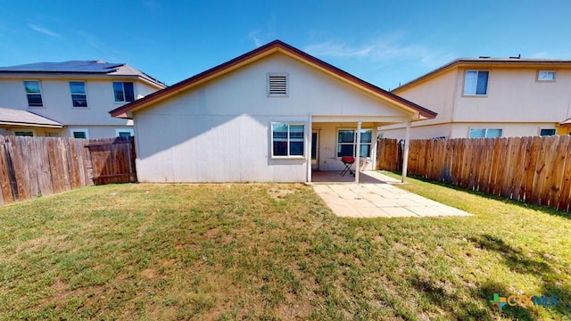 rear view of house with a patio and a lawn