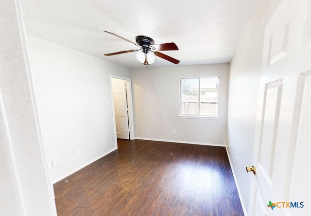 unfurnished room featuring ceiling fan and dark wood-type flooring