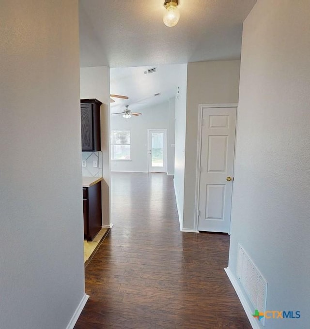 hall with dark wood-type flooring and lofted ceiling