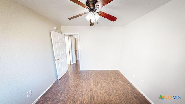 empty room featuring ceiling fan and dark wood-type flooring