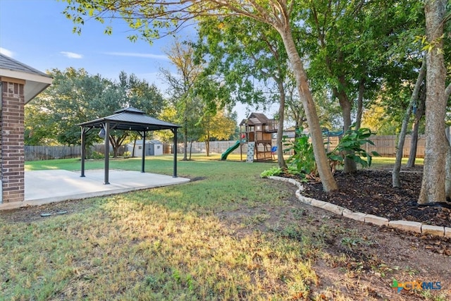 view of yard featuring a playground, a gazebo, and a patio area