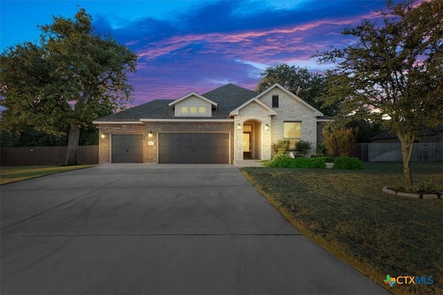 view of front of property with a garage and a lawn