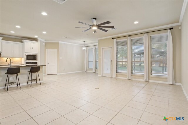 tiled living room featuring ceiling fan, crown molding, and sink