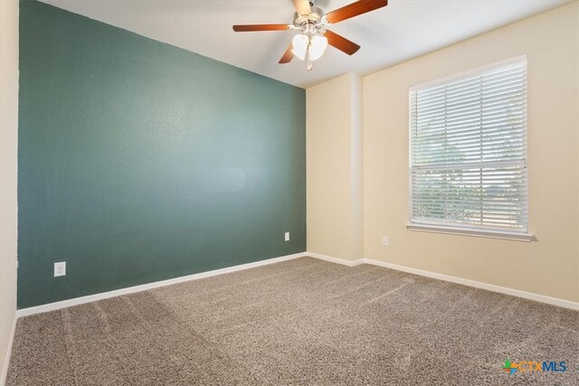 carpeted empty room featuring ceiling fan