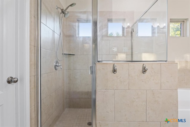 bathroom with a shower with door