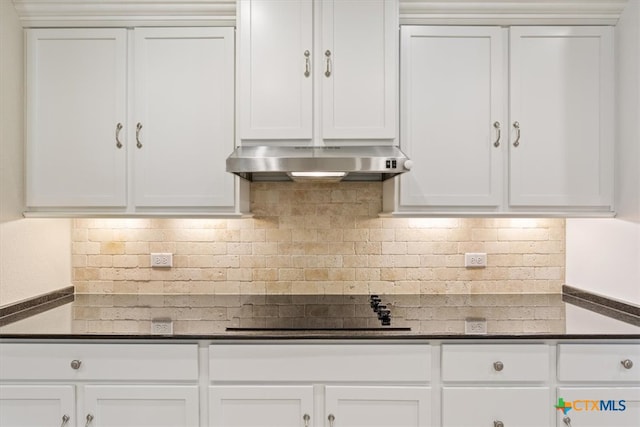 kitchen featuring extractor fan, black electric stovetop, backsplash, and white cabinets