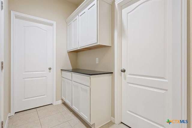 laundry area with light tile patterned flooring