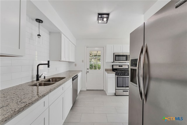 kitchen with sink, white cabinets, hanging light fixtures, and appliances with stainless steel finishes