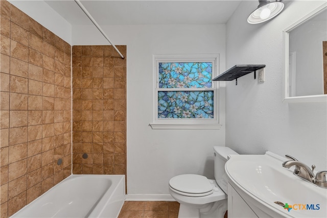 full bathroom featuring toilet, tile patterned floors, tiled shower / bath, and sink