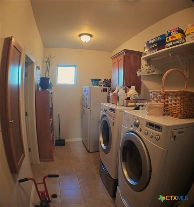 laundry room with cabinets, washer and dryer, and light tile patterned floors